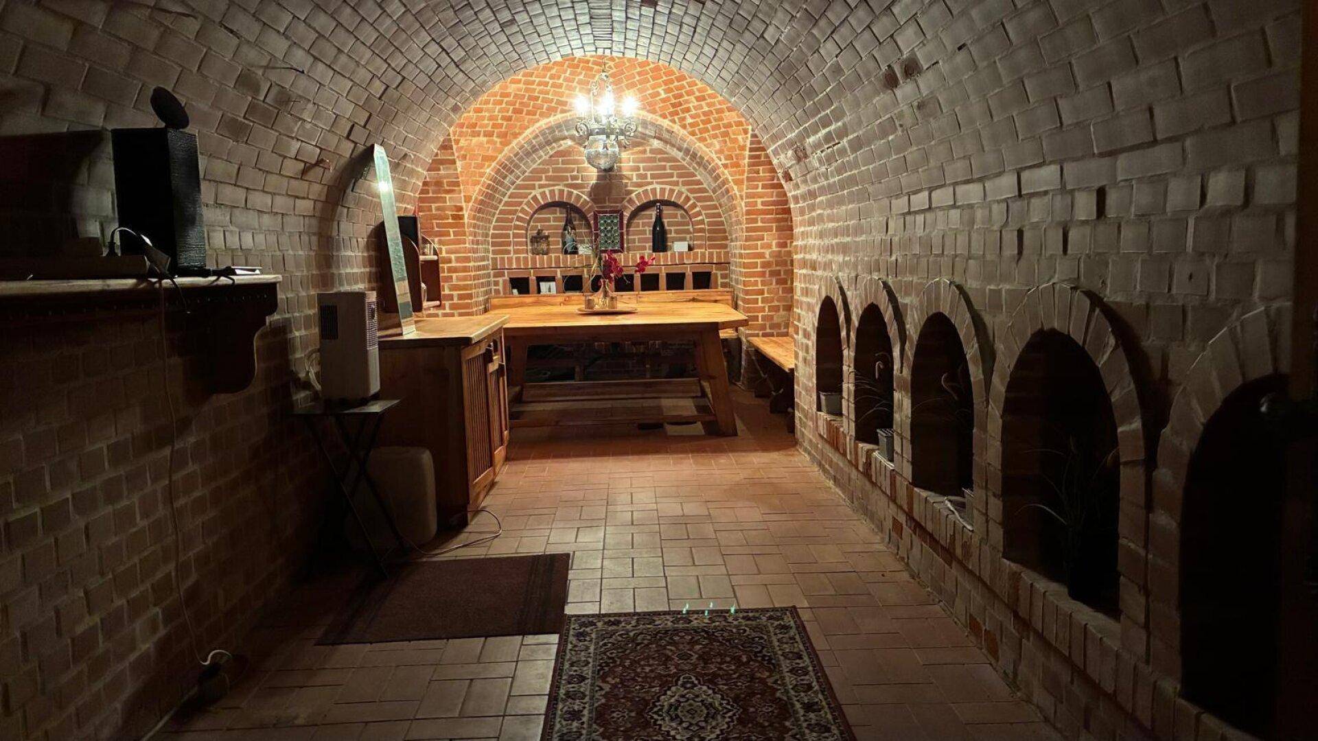 Historischer Weinkeller mit beeindruckendem Ziegelgewölbe und gemütlicher Atmosphäre für gesellige Runden.