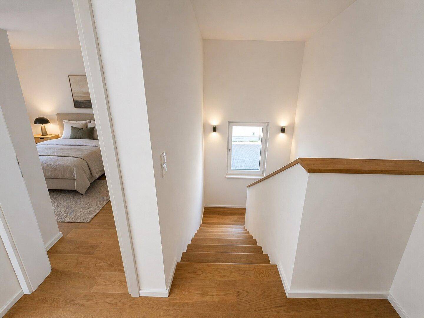 Treppenaufgang mit Holzdielen und Blick in ein helles Schlafzimmer im Obergeschoss.