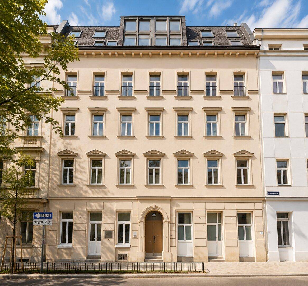 Gesamtansicht des historischen Gebäudes von der Straße mit vielen Fenstern.