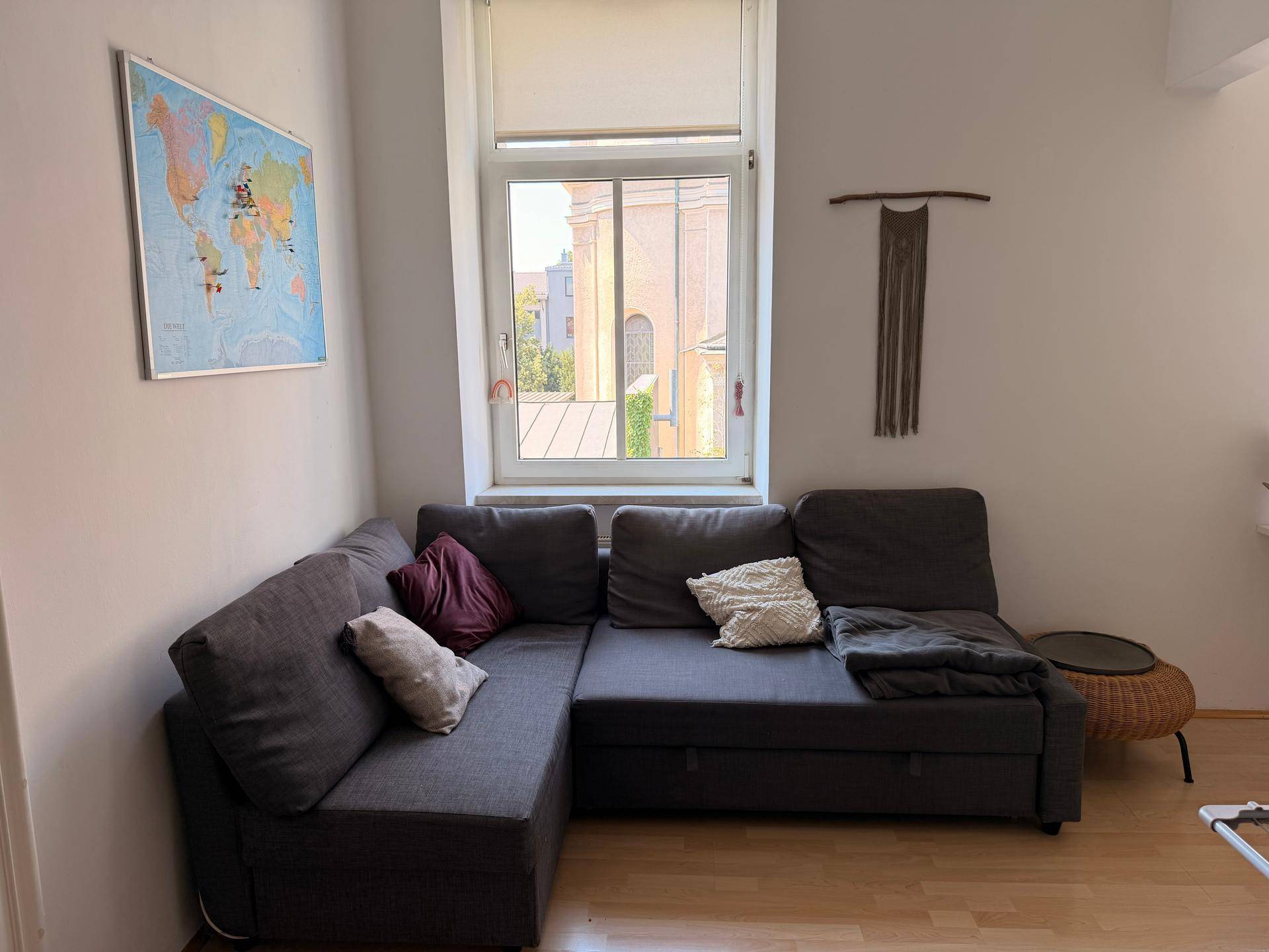 Gemütliches Wohnzimmer mit Ecksofa und Blick auf die umliegenden Gebäude.