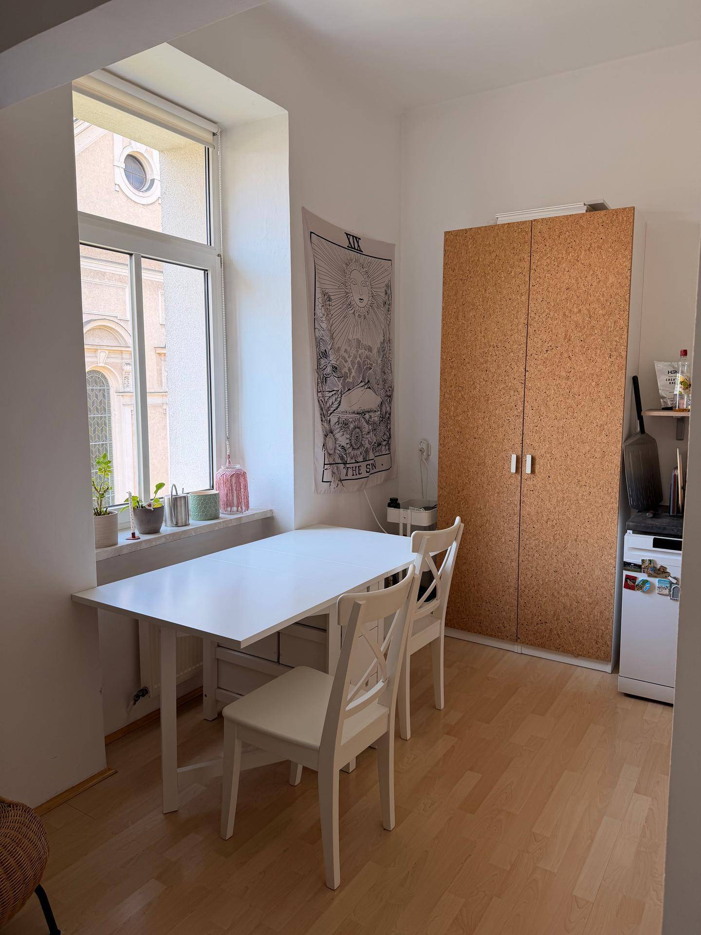 Kleiner Essbereich mit Tisch und Stühlen neben einer funktionalen Küchenzeile.