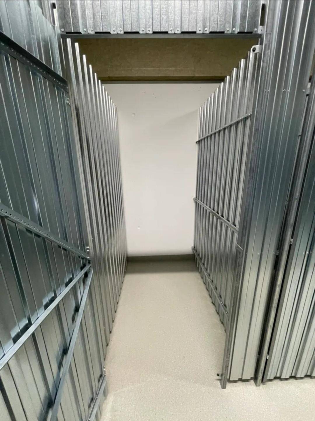 Abstellräume im Kellerbereich mit Metallabtrennungen für zusätzlichen Stauraum.
