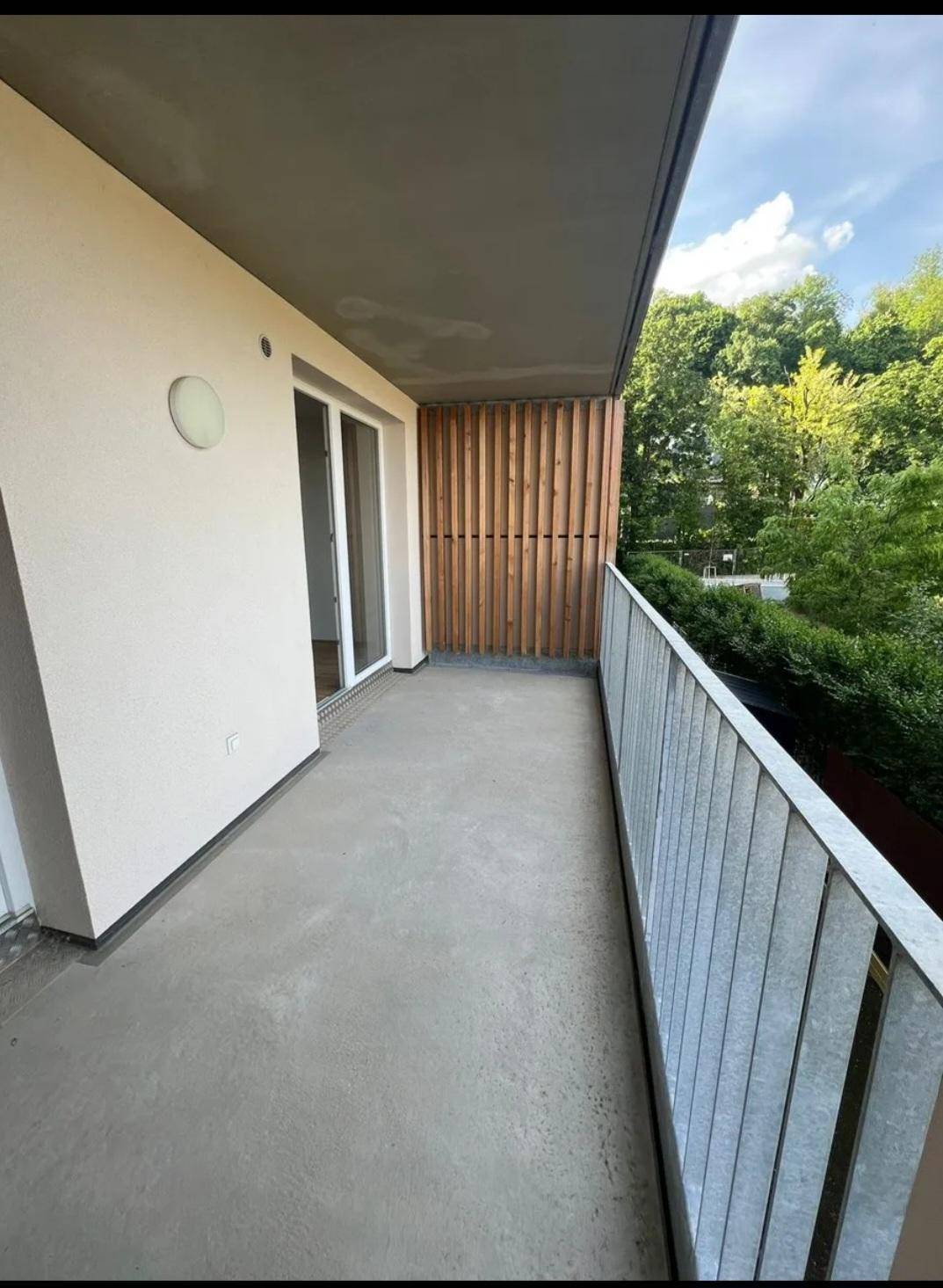 Balkon mit Holzelementen und Blick ins Grüne, ideal für entspannte Stunden im Freien.