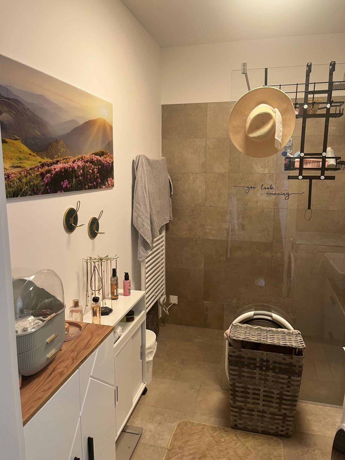 Helles Badezimmer mit begehbarer Dusche, Waschtisch und beheiztem Handtuchhalter, modern ausgestattet.