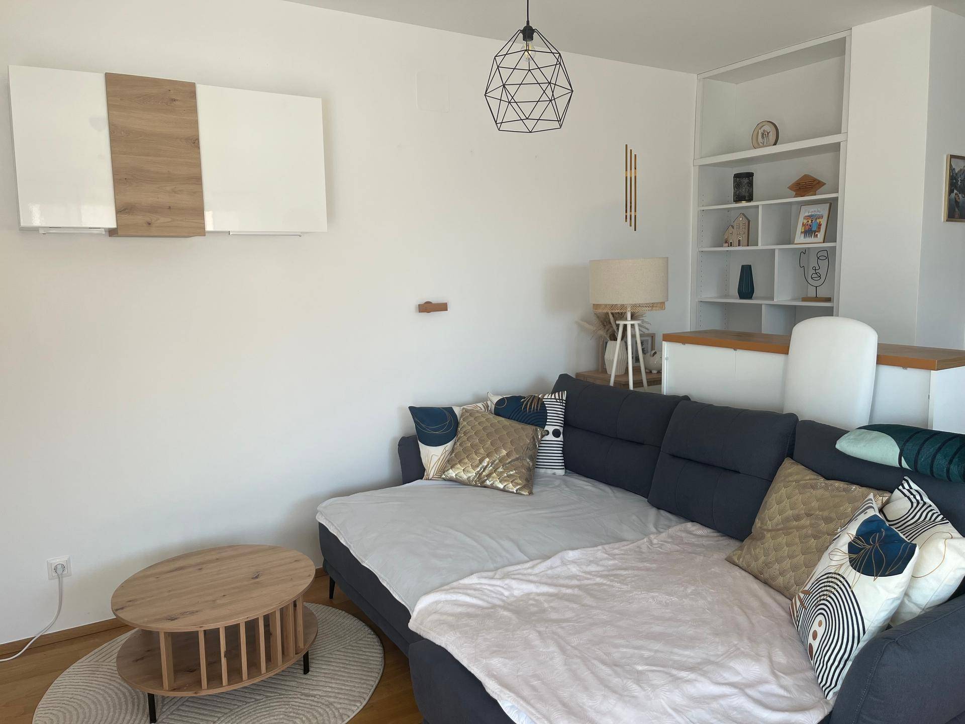 Gemütliches Wohnzimmer mit großem Ecksofa, Couchtisch und dekorativen Regalen, hell und einladend.
