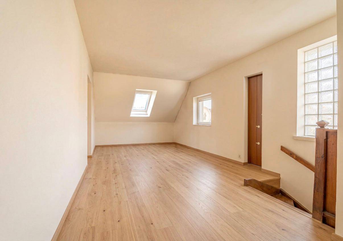 Renovierter Dachbodenbereich mit Holzboden, Dachfenstern und viel natürlichem Licht.