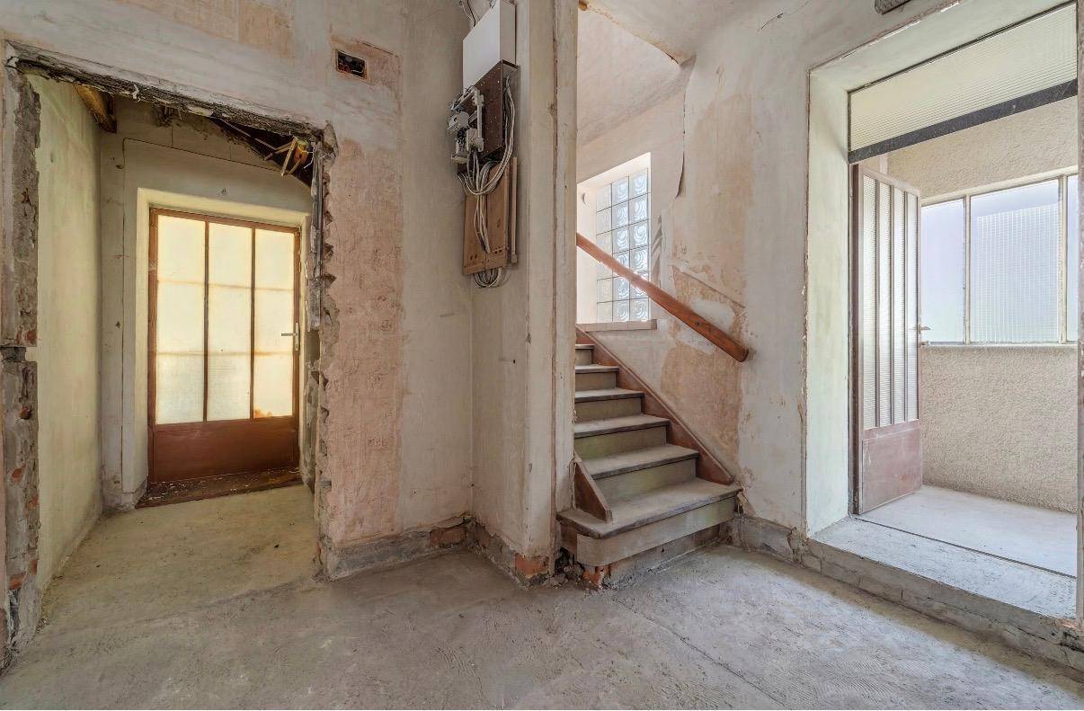 Unausgebauter Flurbereich mit Treppe und sichtbaren Bauarbeiten, bereit für die Renovierung.