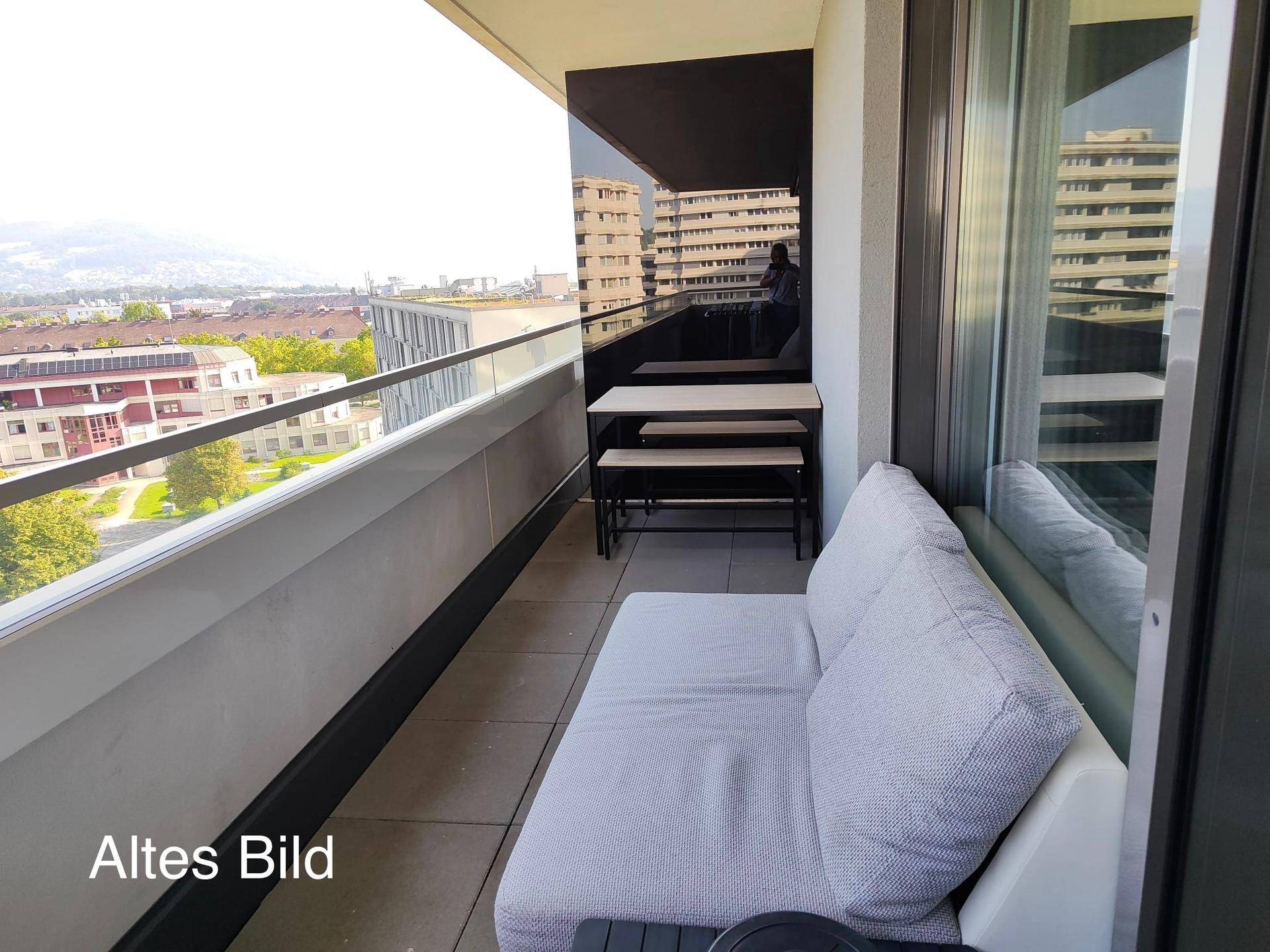 Geräumiger Balkon mit Sitzgelegenheiten und Blick auf die umliegende Stadt.
