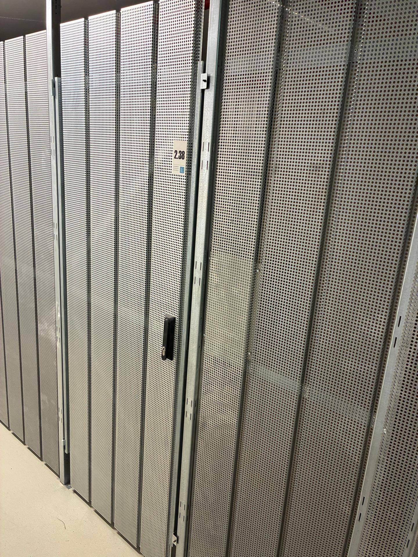 Reihen von Metall-Lagerabteilen in einem Kellerraum für zusätzlichen Stauraum.