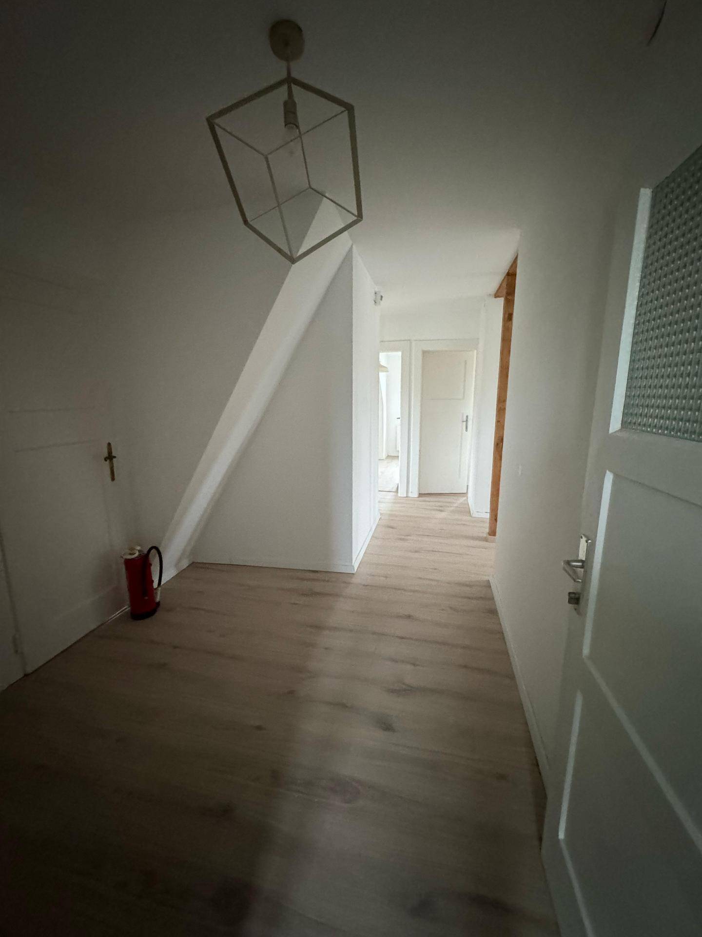 Heller Flur im Dachgeschoss mit Laminatboden, schrägen Wänden und Türen zu weiteren Räumen.