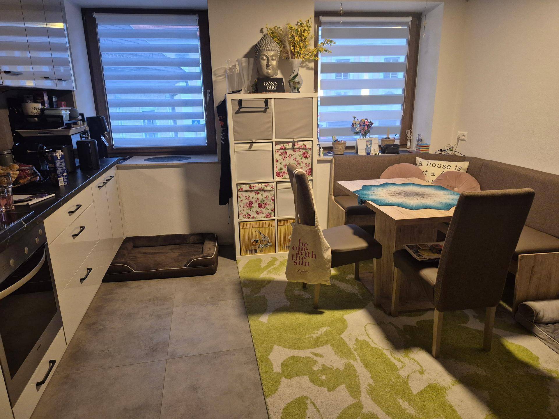 Gemütliche Wohnküche mit Essbereich, Fenster und dekorativen Elementen.