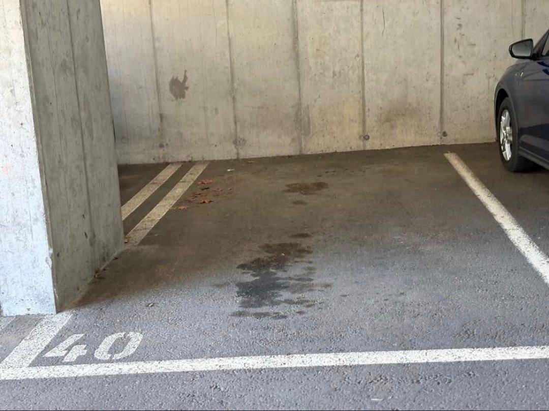 Parkplatz in einer Tiefgarage mit Betonwänden und markierten Stellflächen.