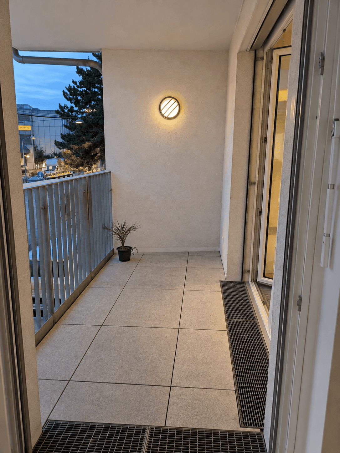 Balkon bei Abenddämmerung mit Beleuchtung und Blick auf die Umgebung.