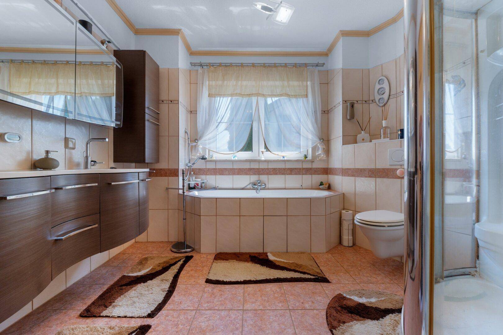 Geräumiges Badezimmer mit Eckbadewanne, separater Duschkabine und Doppelwaschbecken.