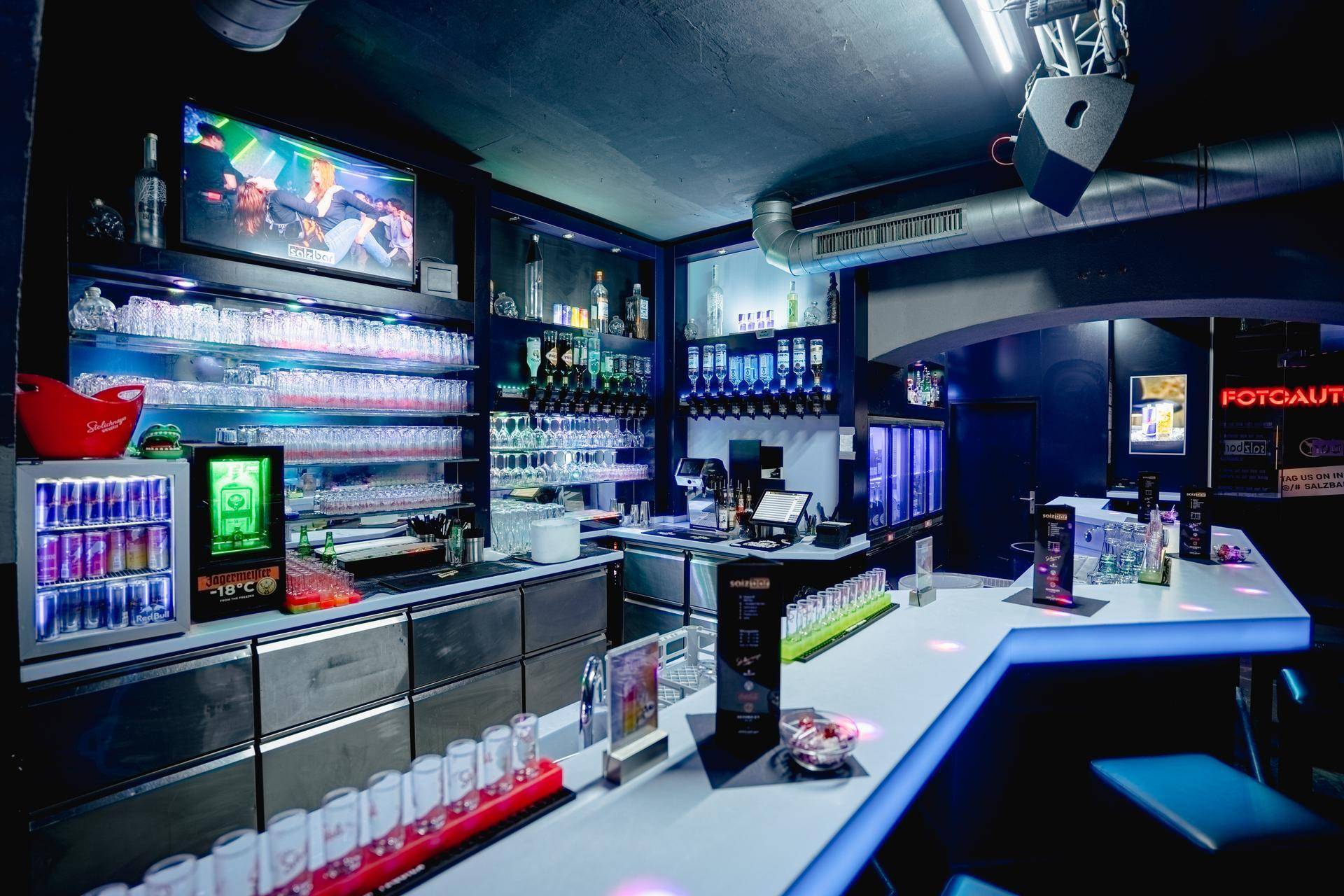 Detaillierte Ansicht der Bar mit einer Vielzahl von Gläsern, Flaschen und Kühlschränken, bereit für den Service.