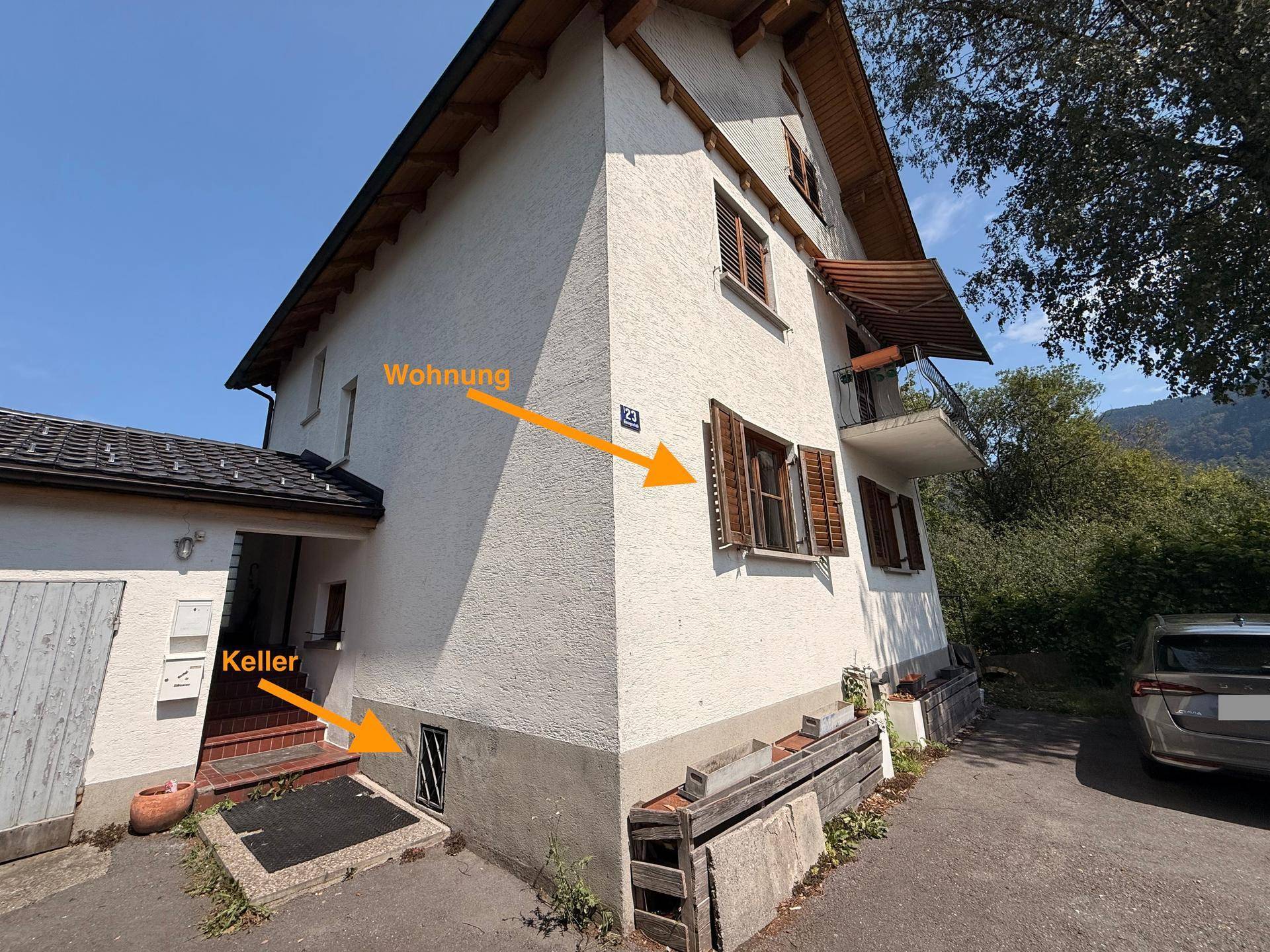 Außenansicht des Gebäudes mit Zugang zum Keller und den Fenstern der Wohnung.
