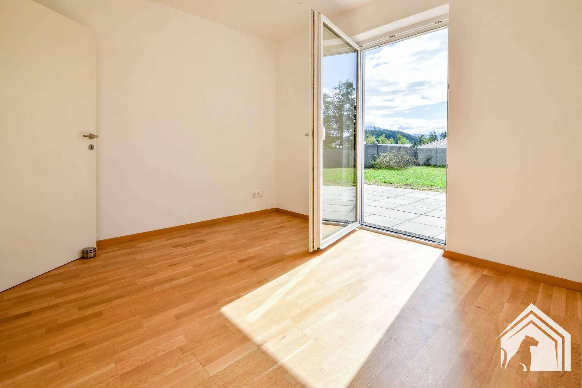 Helles Zimmer mit Parkettboden und direktem Zugang zum Garten, ideal als Schlaf- oder Arbeitszimmer.