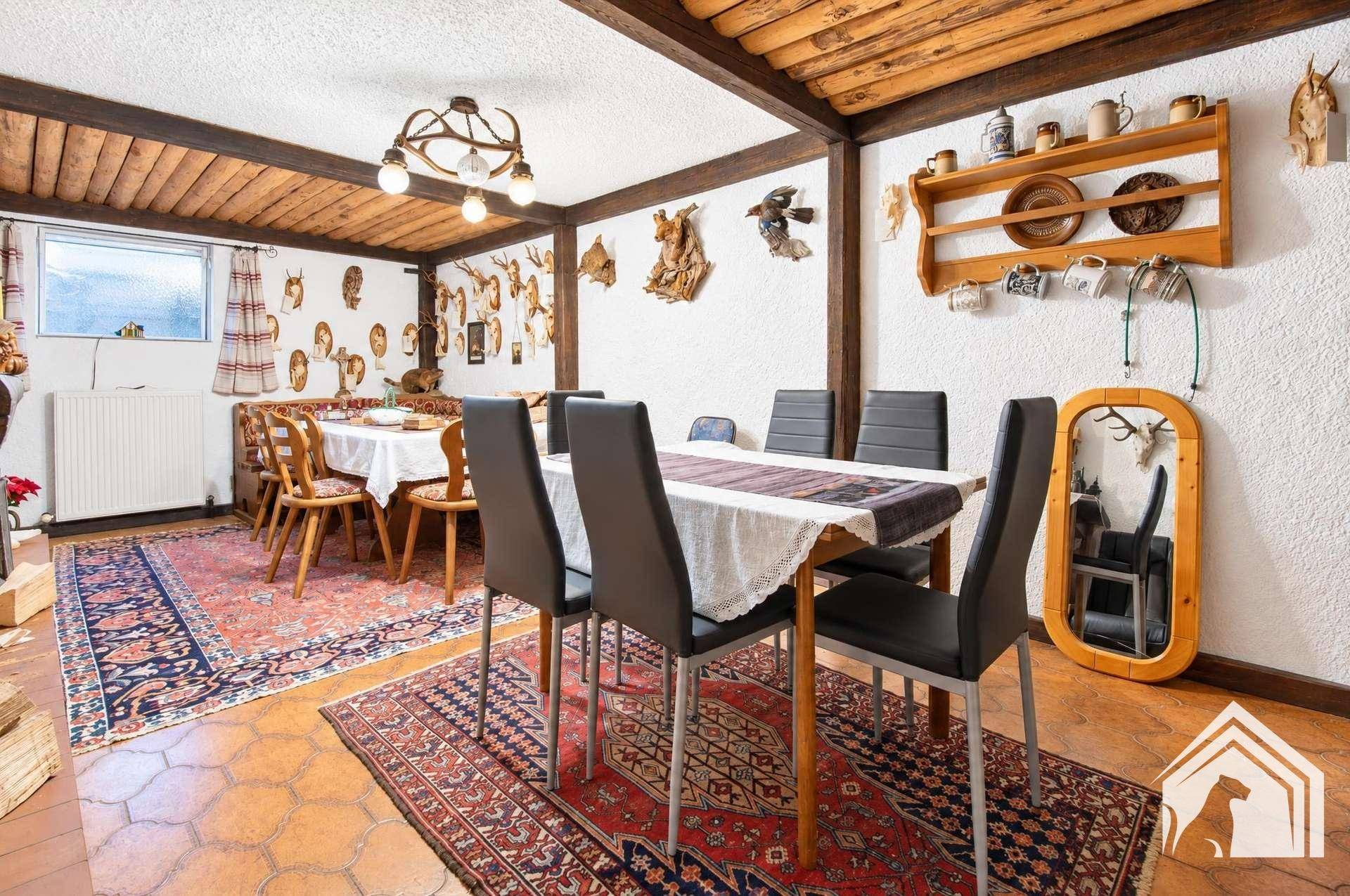 Rustikaler Essbereich mit Holzbalkendecke, traditioneller Dekoration und großem Esstisch.