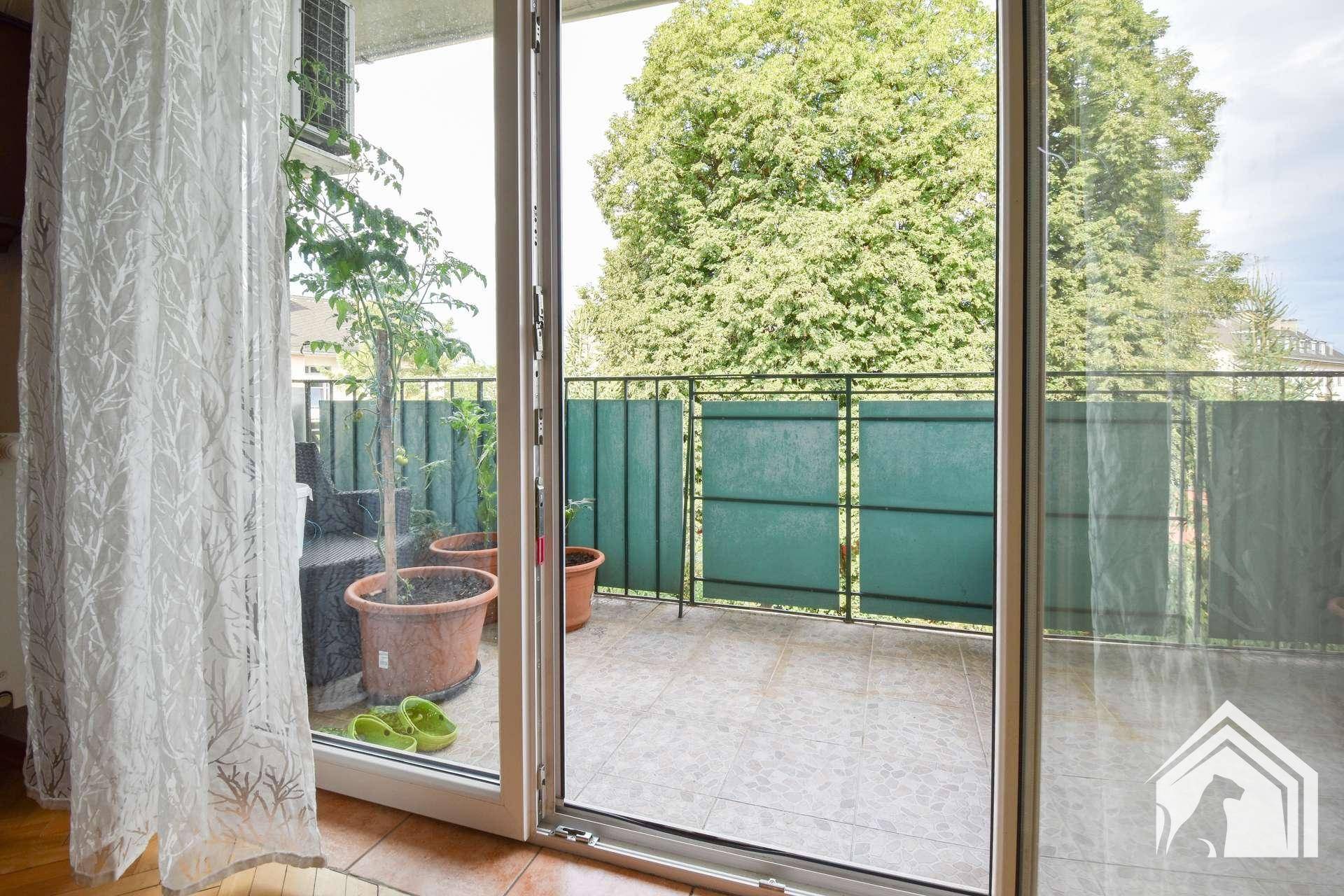 Geräumiger Balkon mit Fliesenboden und Blick ins Grüne, ideal zum Entspannen.