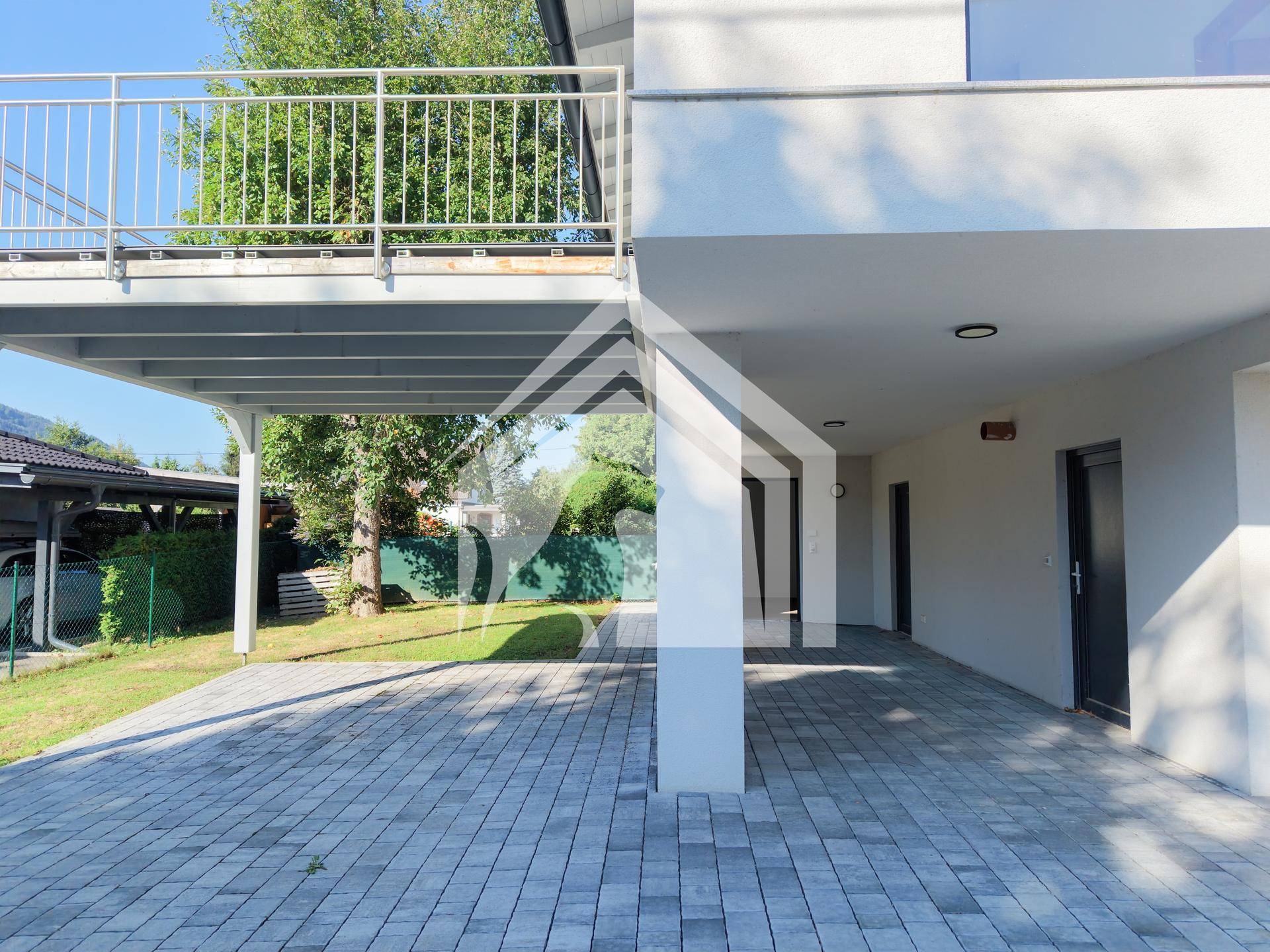 Überdachter Bereich unter dem Balkon, ideal als Carport oder geschützter Eingangsbereich.