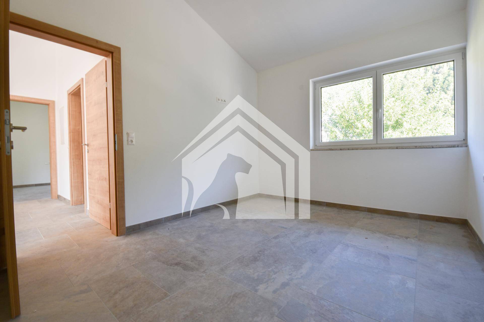 Heller Raum mit Fliesenboden und Fenster, bietet flexible Nutzungsmöglichkeiten für Bewohner.