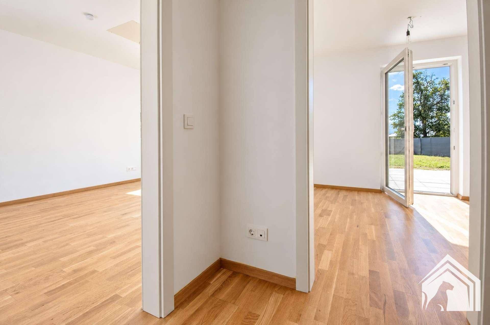 Heller Flur mit Parkettboden, der verschiedene Räume der Wohnung miteinander verbindet.