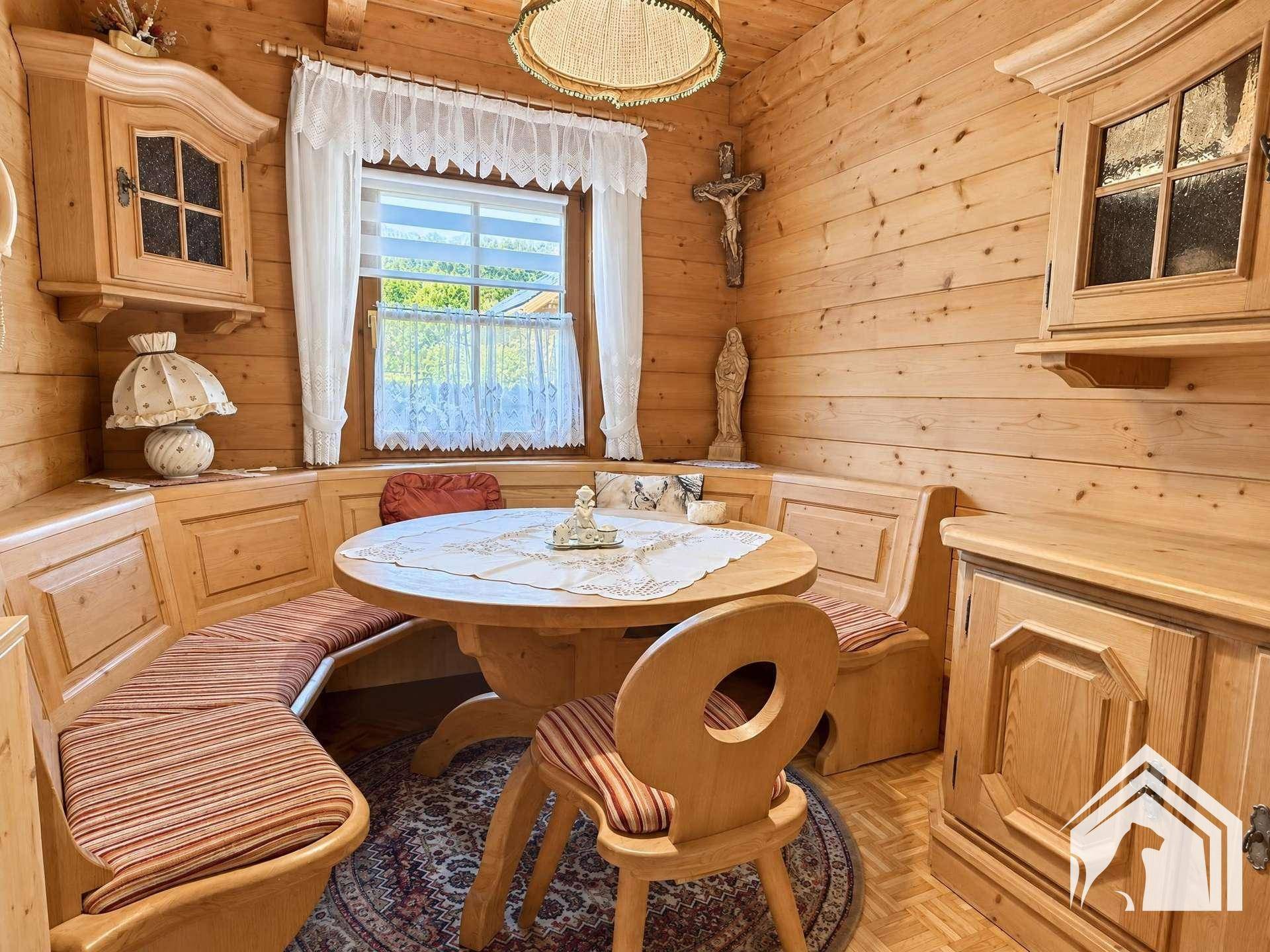 Gemütliche Essecke im alpenländischen Stil mit Holzbänken und traditioneller Dekoration.