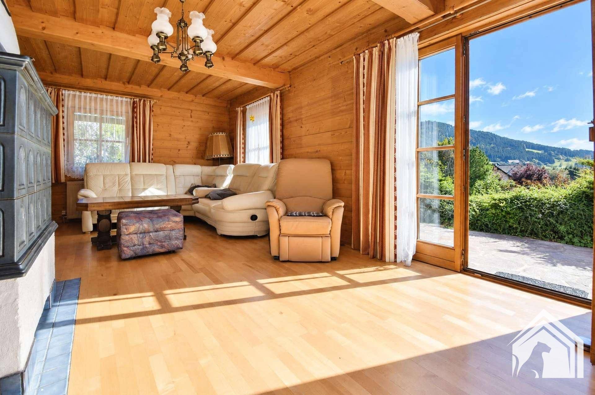 Helles Wohnzimmer mit Holzboden, bequemen Sofas und Zugang zur Terrasse mit Bergblick.