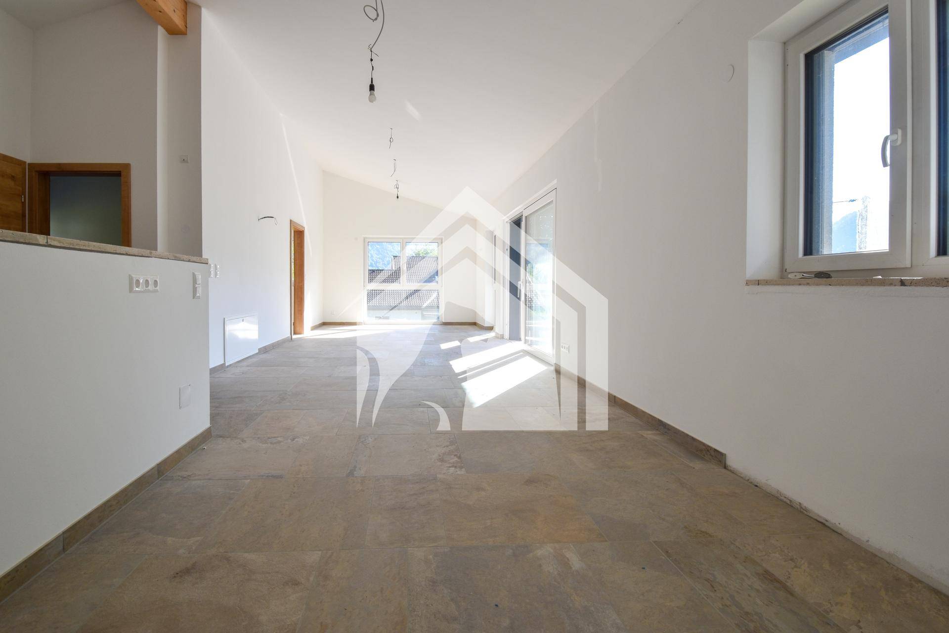 Geräumiger, heller Wohnbereich mit großen Fenstern, Fliesenboden und Zugang zum Balkon.