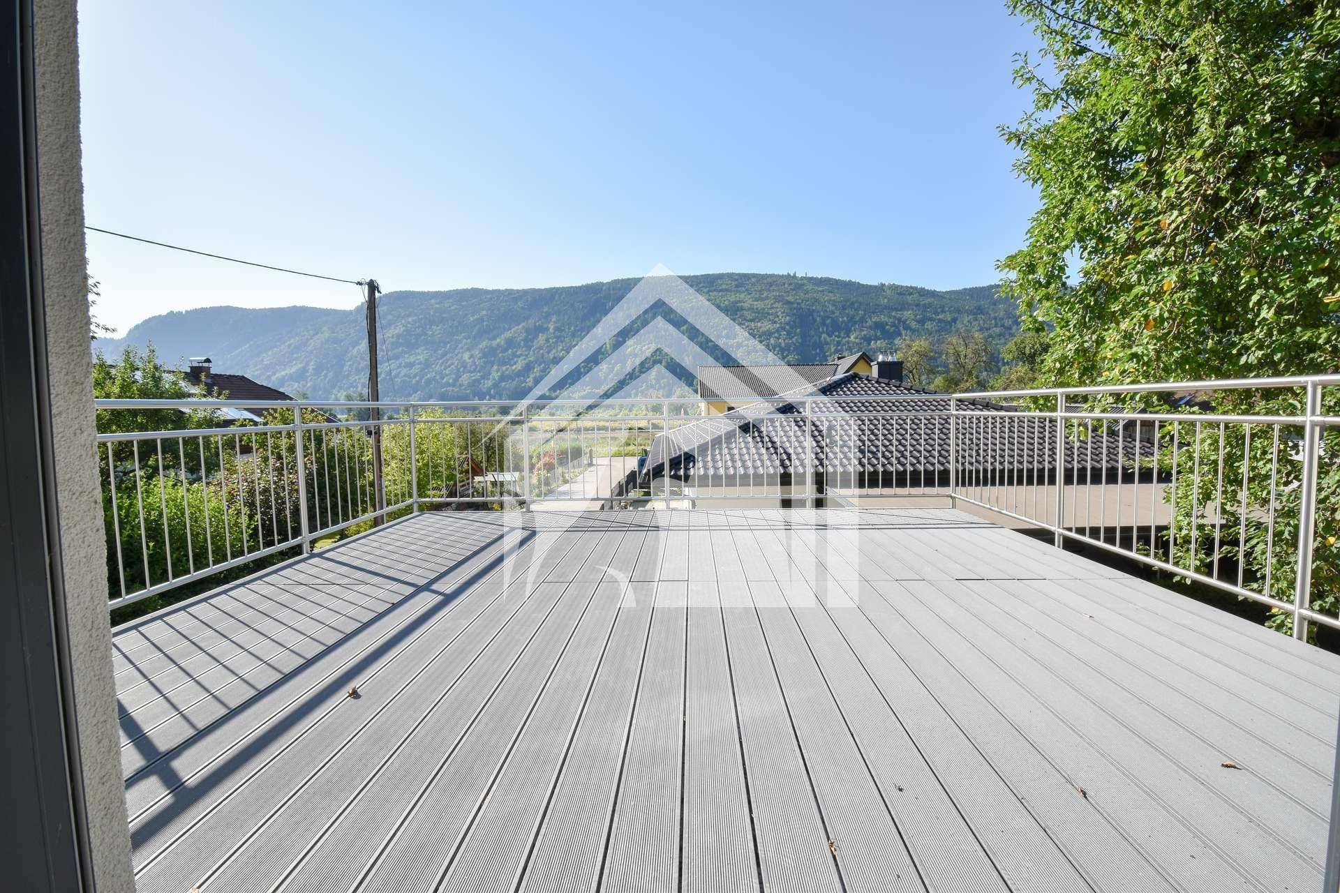 Weitläufiger Balkon mit Blick auf die umliegende Berglandschaft und viel Sonnenlicht.