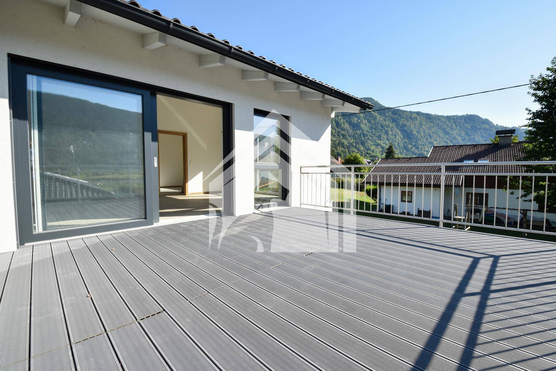 Großer Balkon mit modernen Bodenbelägen und weitem Blick auf die umliegende Berglandschaft.