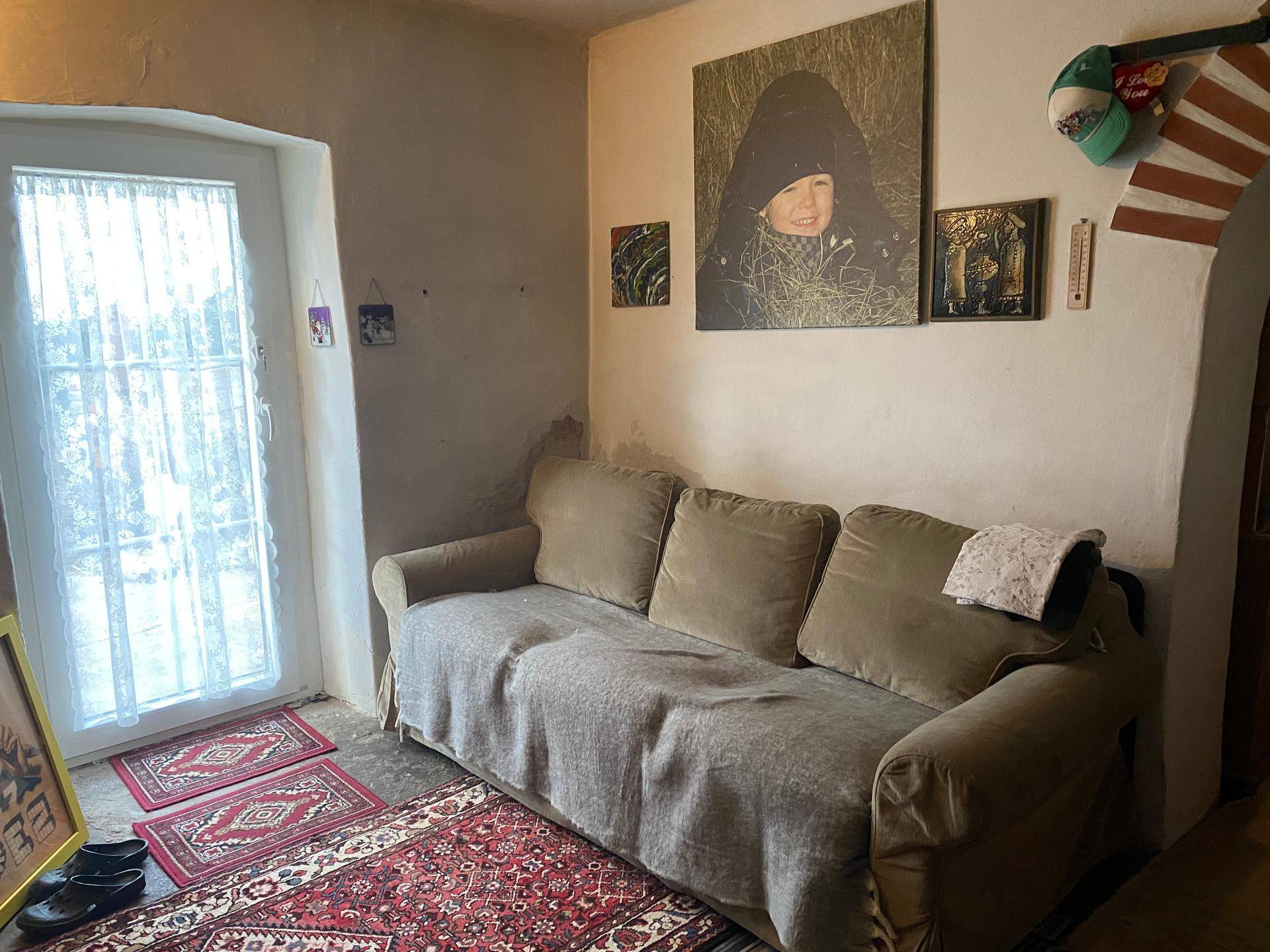 Wohnzimmer mit Sofa, Teppich und Fenster, hell und gemütlich eingerichtet.