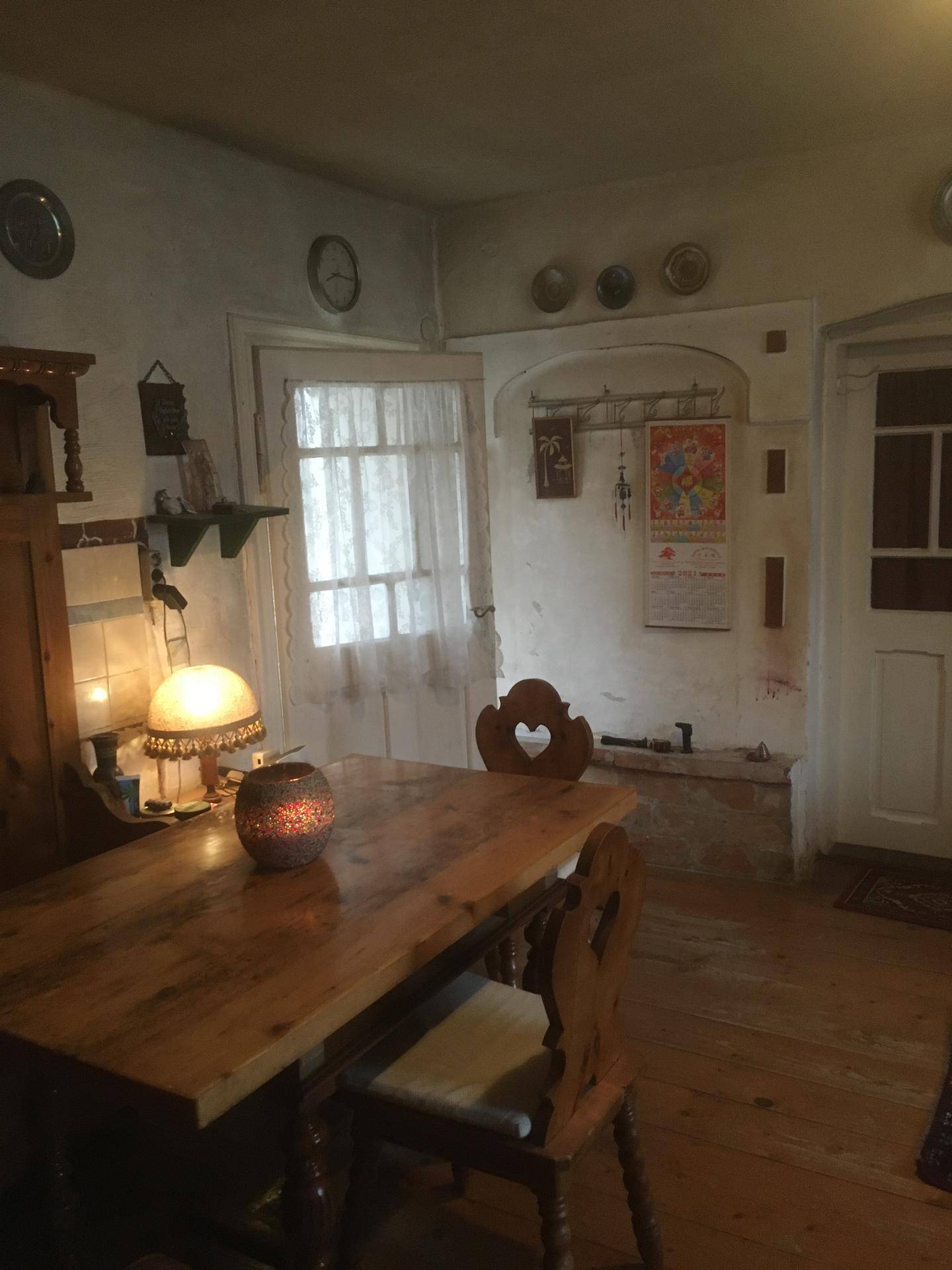 Traditionelle Essecke mit Holztisch, Stühlen und dekorativen Elementen an der Wand.