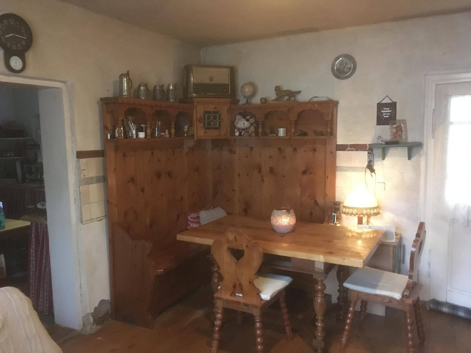 Gemütliche Essecke mit Holztisch, Eckbank und traditionellen Holzstühlen.