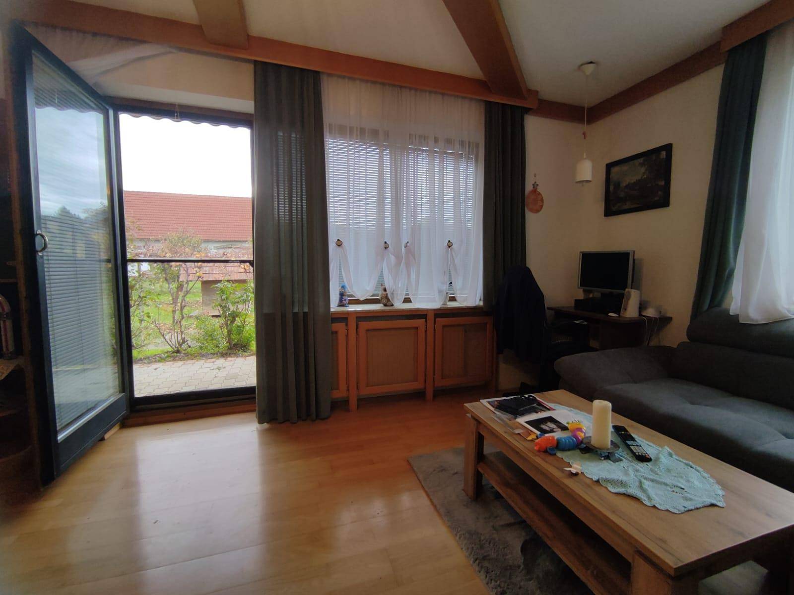 Helles Wohnzimmer mit Parkettboden und direktem Zugang zum Außenbereich.