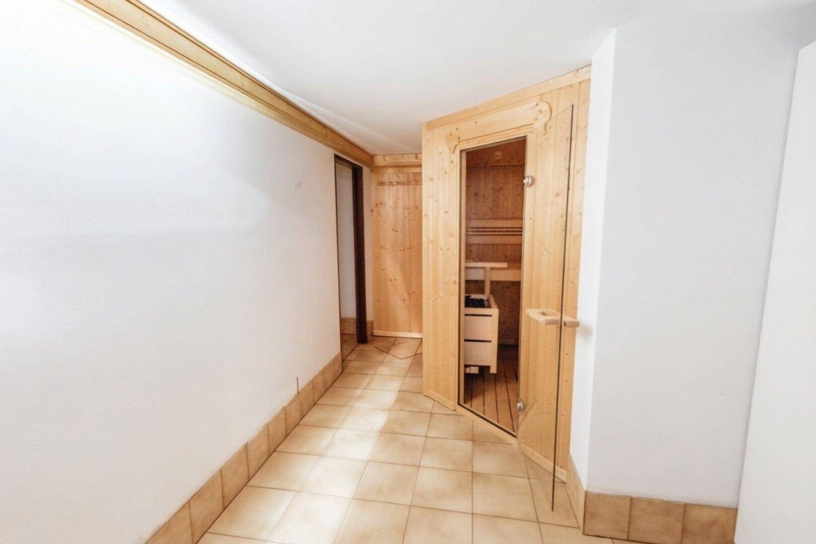 Flur mit Zugang zu einer holzvertäfelten Sauna, die Entspannung bietet.