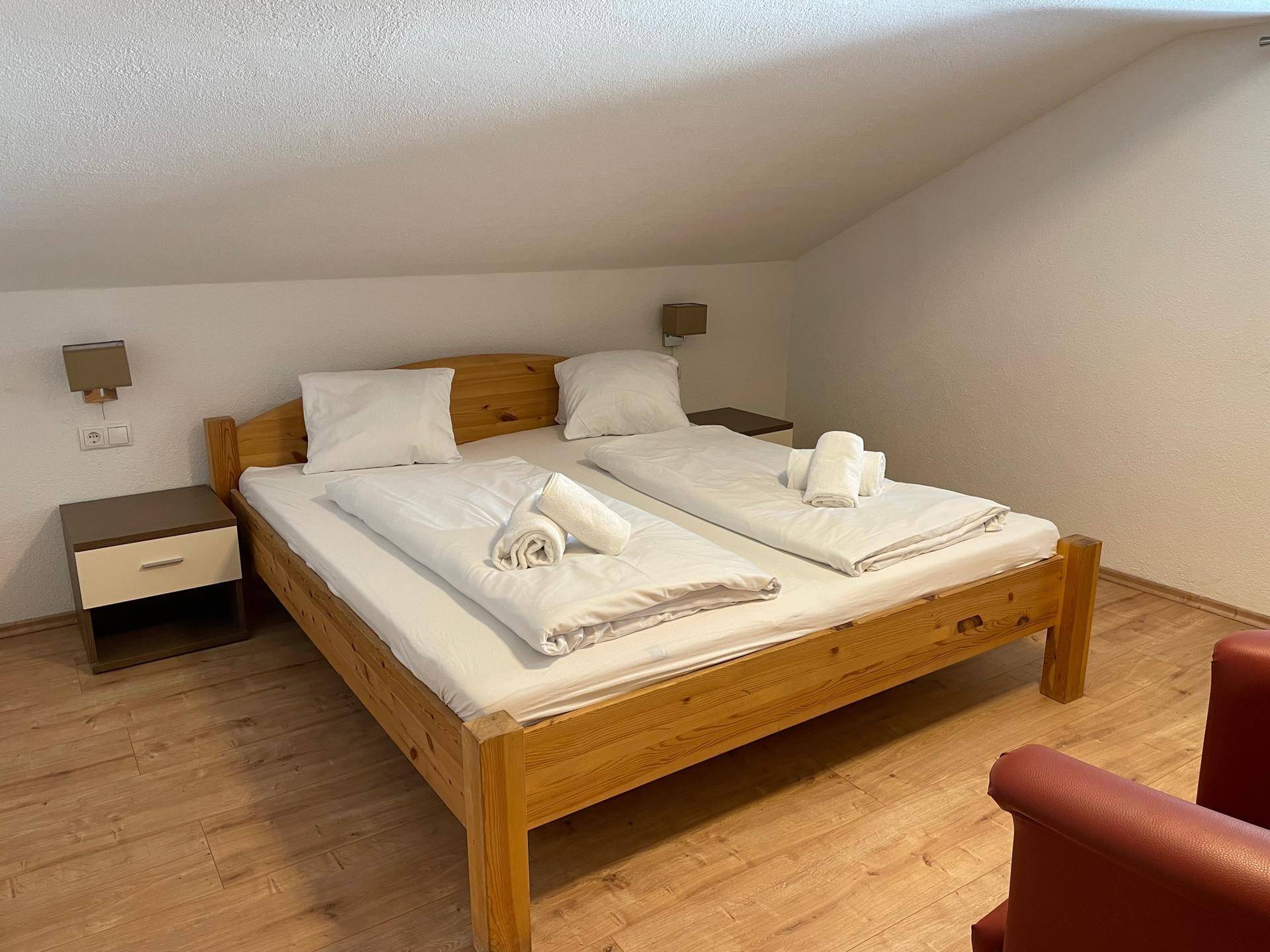Gemütliches Schlafzimmer im Dachgeschoss mit Doppelbett, Holzboden und Dachschräge.