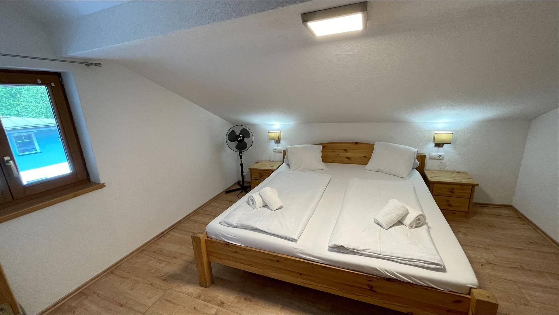 Gemütliches Schlafzimmer im Dachgeschoss mit Doppelbett, Holzboden und Dachschräge.