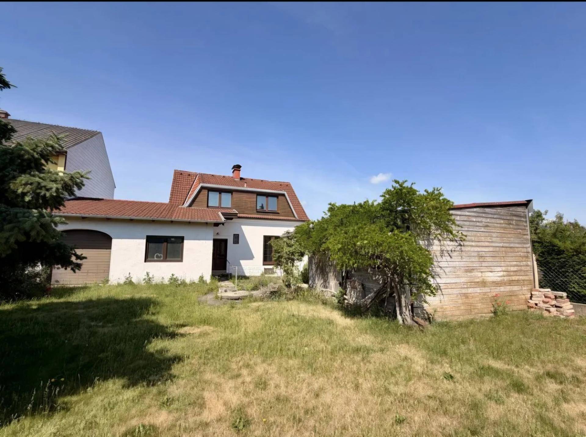 Hinterhof mit großem Garten, Nebengebäude und Blick auf das Einfamilienhaus.