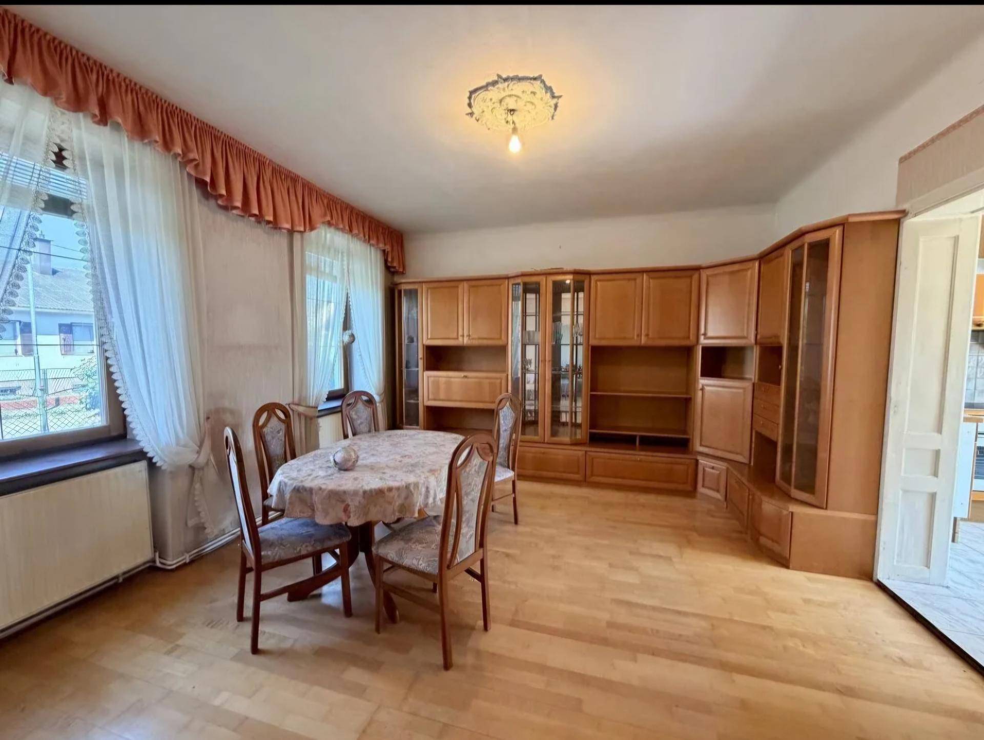 Klassischer Essbereich mit Holzboden, großem Esstisch und Einbauschränken an der Wand.