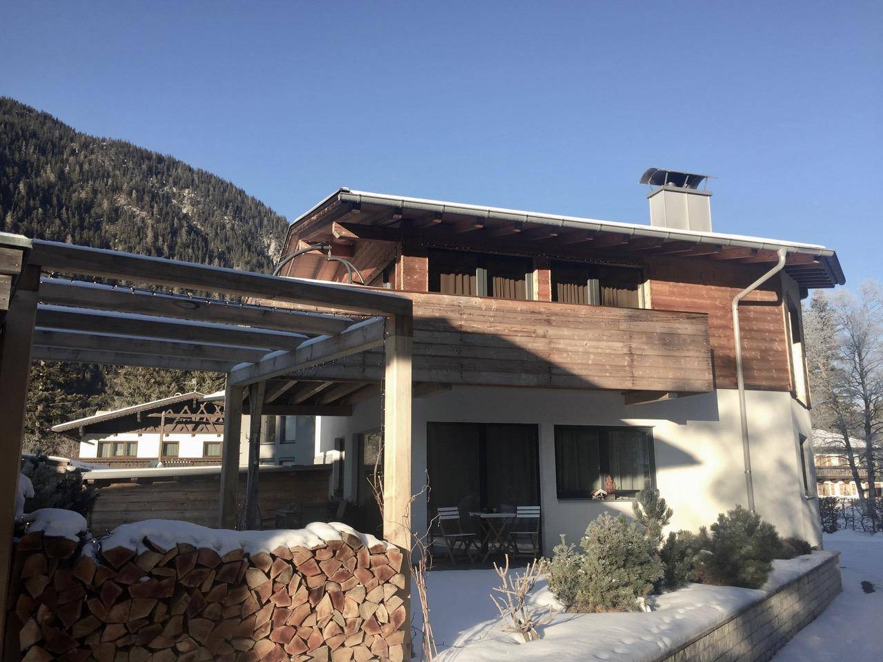 Chalet im Winter mit verschneiter Umgebung, Holzfassade und Bergblick.