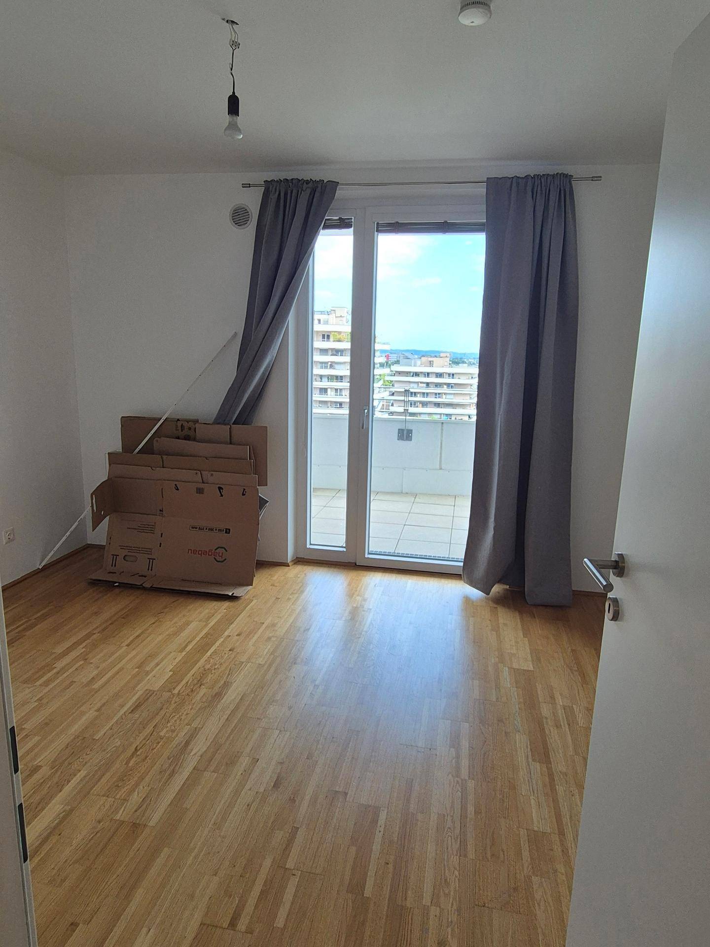 Helles Schlafzimmer mit Holzboden und direktem Zugang zu einer großzügigen Terrasse.