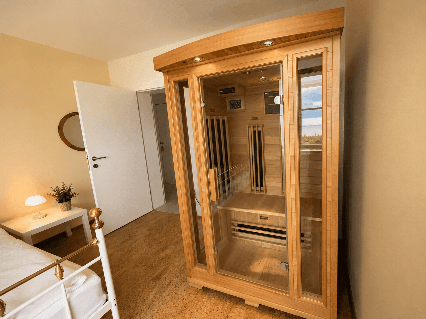 Schlafzimmer mit Infrarotkabine und hellem Korkboden, ideal zur Entspannung.