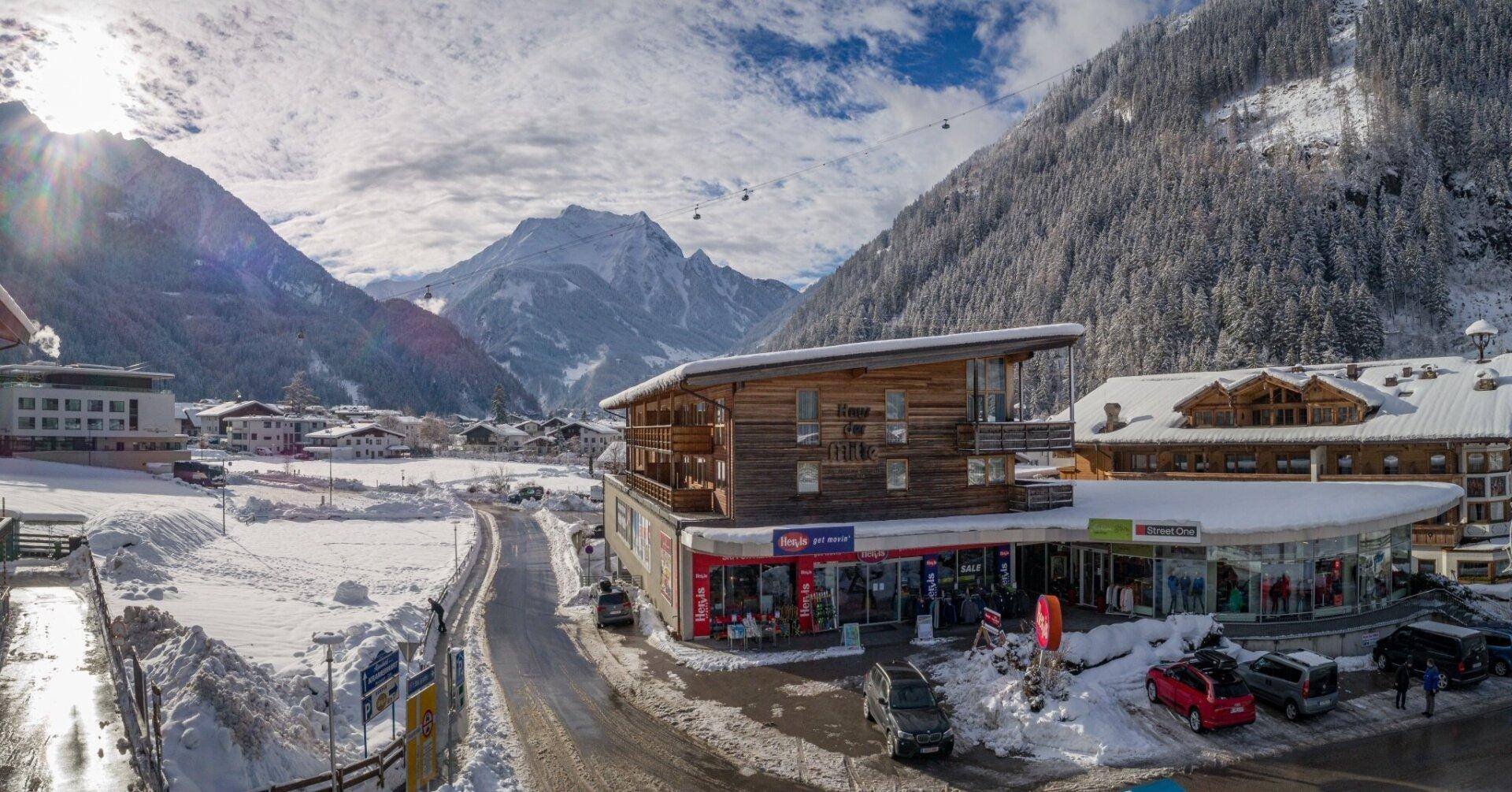 Panoramablick auf das Geschäftsgebäude in einer verschneiten Berglandschaft mit umliegenden Häusern.