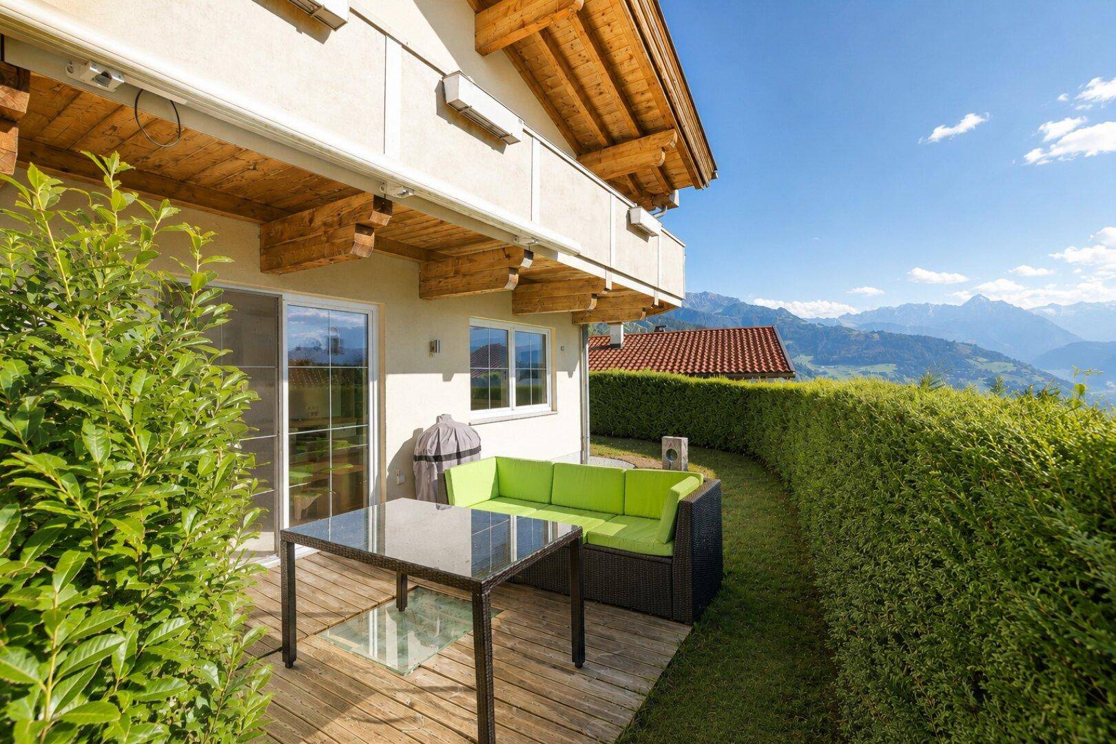 Gemütliche Terrasse mit modernen Gartenmöbeln, Grillbereich und herrlichem Bergblick.