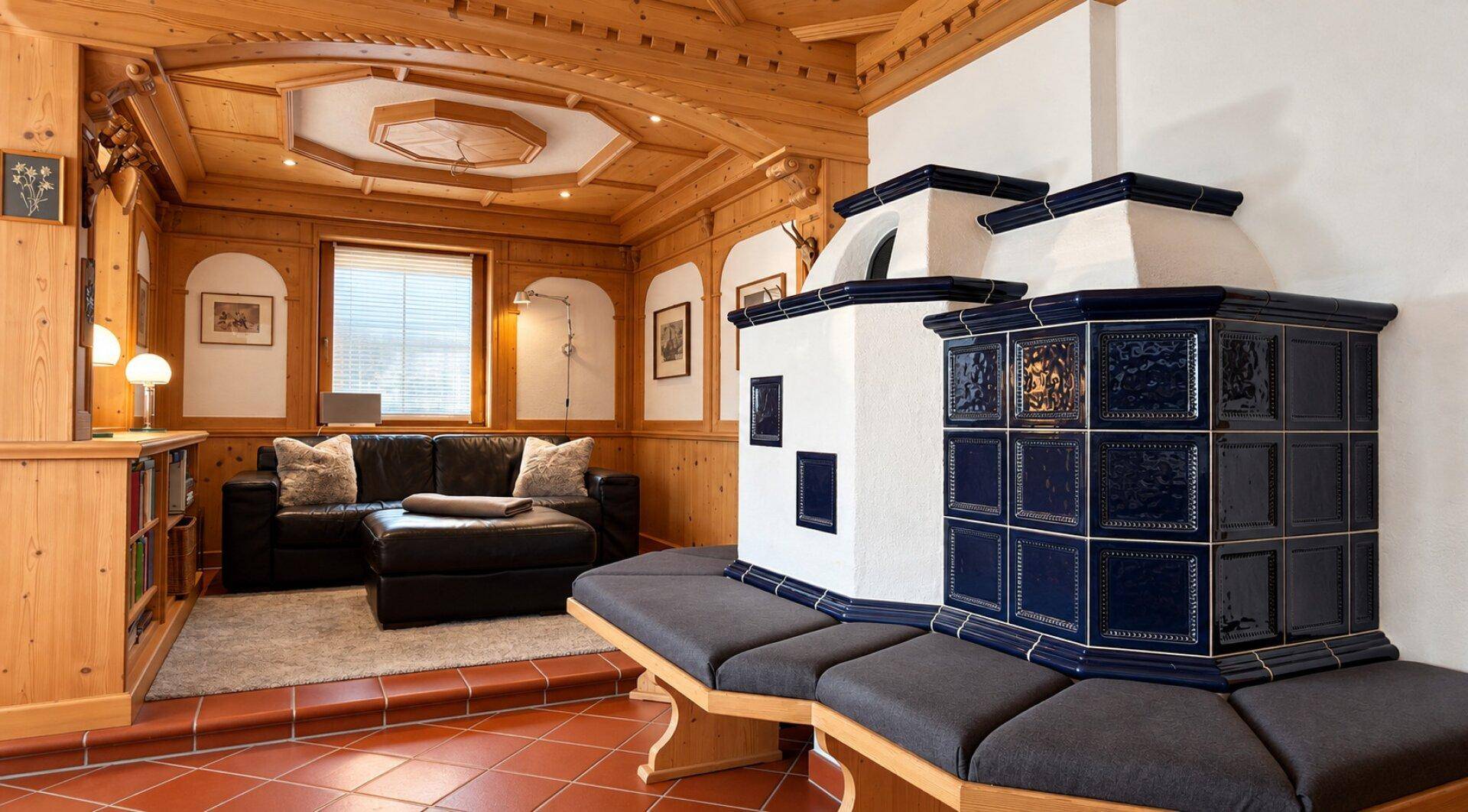 Geräumiger Wohnbereich mit traditionellem Kachelofen und gemütlicher Sitzecke im Landhausstil.