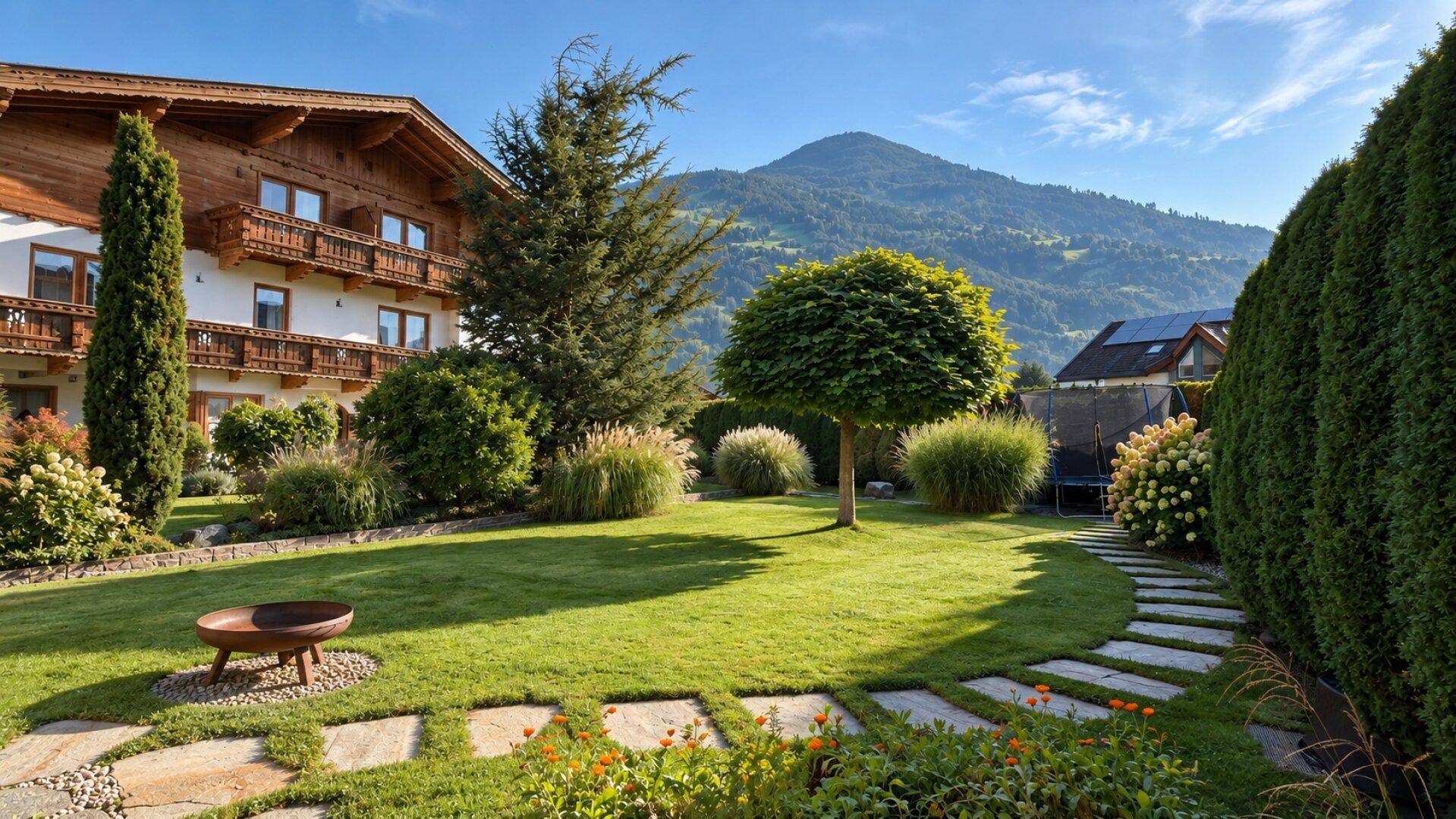 Gepflegter Garten mit Steinpfad, Feuerstelle und Blick auf das traditionelle Gebäude und die Berge.