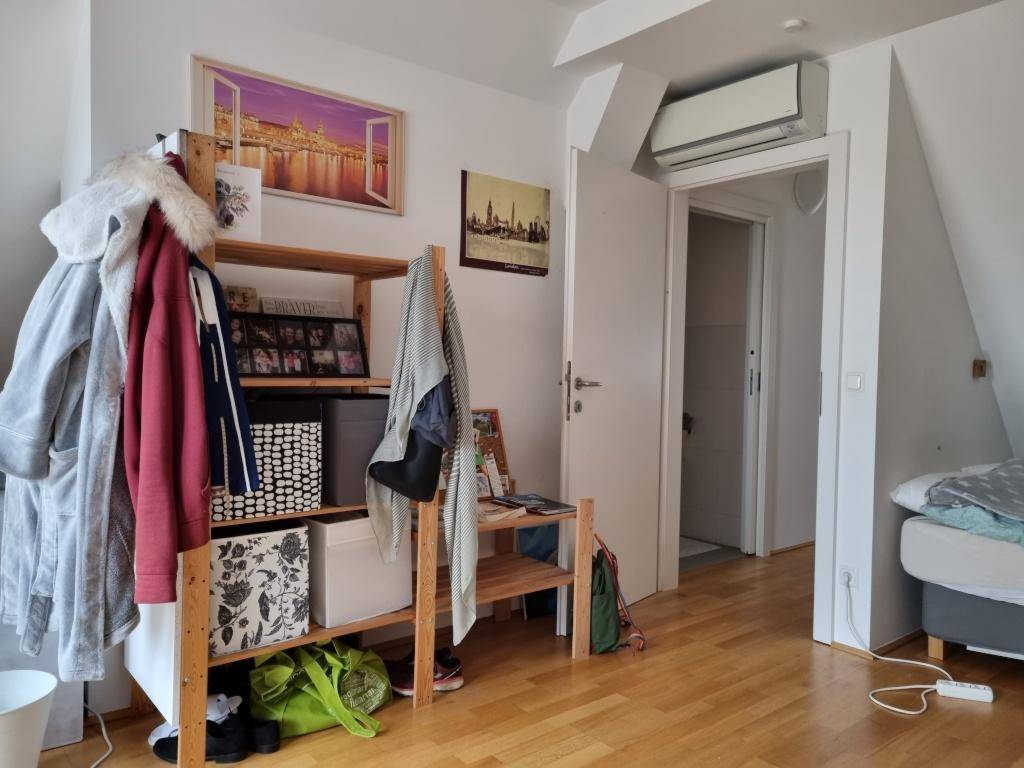 Detailansicht des Dachzimmers mit Klimaanlage über der Tür und Holzboden.