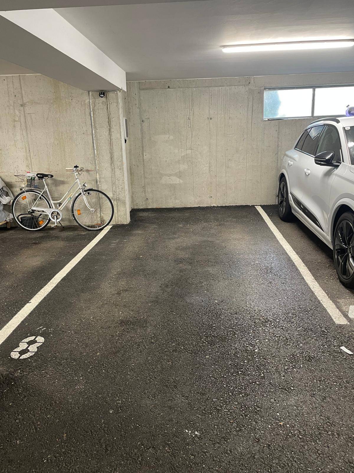 Tiefgaragenstellplatz mit ausreichend Platz für ein Fahrzeug und ein Fahrrad.
