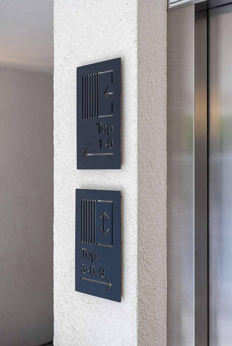 Beschilderung für die Etagen im Aufzugsbereich des Gebäudes.